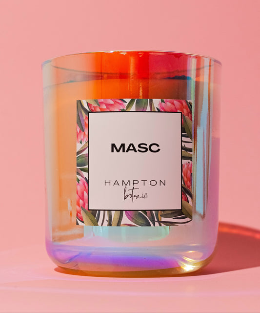 candle in holographic jar with label saying masc against a pink background